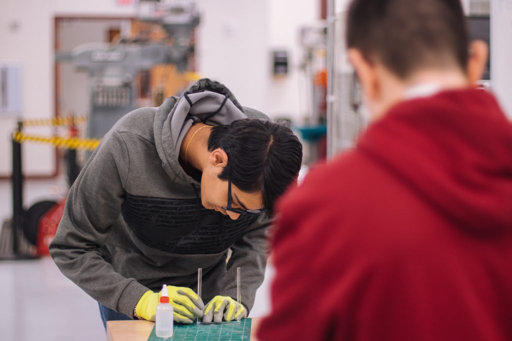 Two students working on a math or engineering problem using hands-on activities.