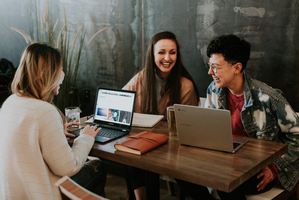 three students gathered around a table using classroom technology