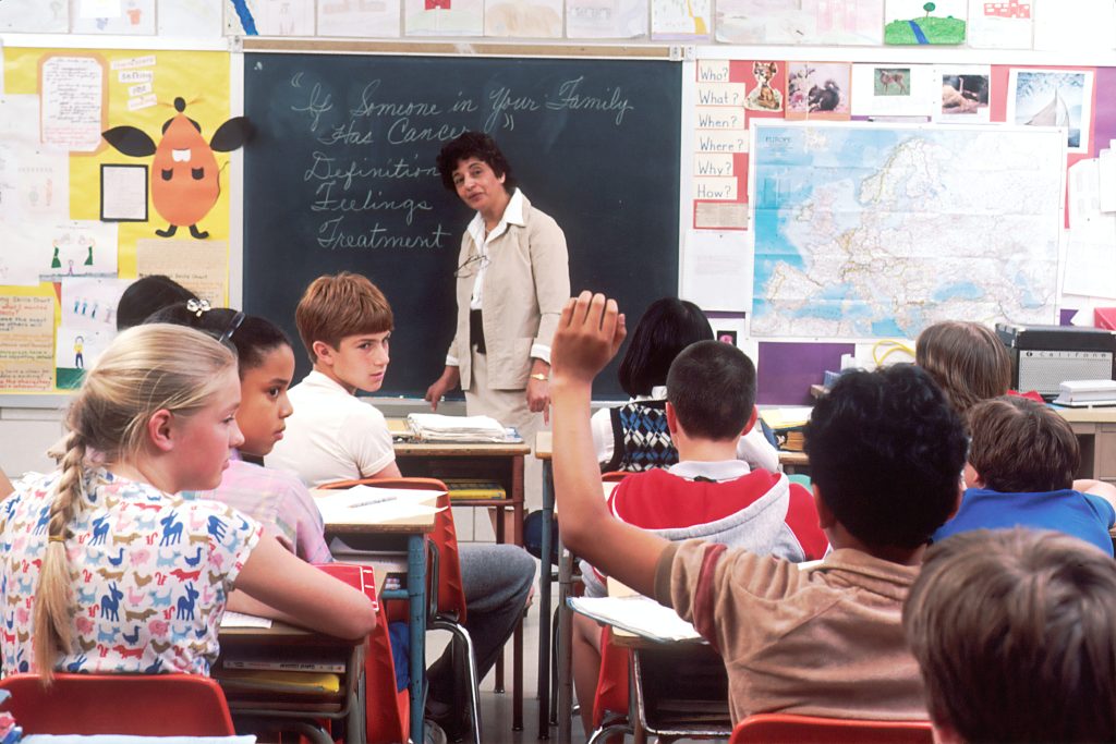 teacher standing in front of classroom of children