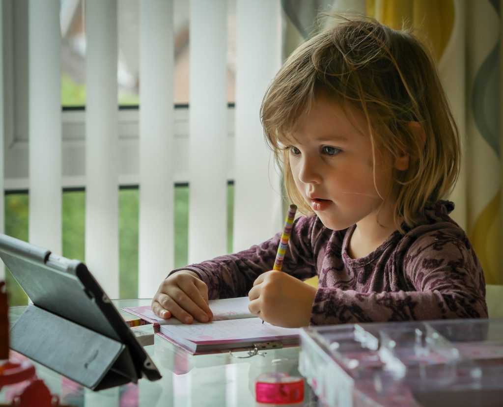 Girl using technology to learn at home