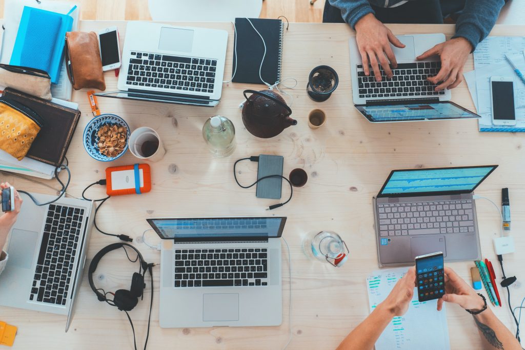 View of desk with students working and using technology